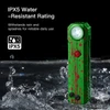 IPX5 water resistant green flashlight with red splatters glowing amidst splashing water on a dark background