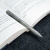 Sleek titanium pen resting on an open book, perfect for jotting notes while reading or studying.