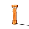 Orange Prowess rechargeable LED flashlight standing upright while charging with USB cable on white background
