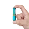 Hand holding compact blue and gold Olight i3E EOS keychain flashlight, showing its ultra-small size against white background