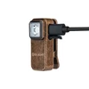 Olight compact clip-on flashlight in textured bronze charging with a USB cable, isolated on white background