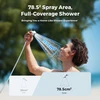 Man using a Flextail portable outdoor shower showing a wide 78.5 square centimeter spray area on a beach