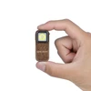 Hand holding a compact bronze Olight EDC keychain flashlight against a white background