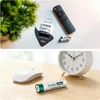 Olight Ecolast AAA 800mAh Ni-MH rechargeable batteries in packaging and next to a remote, mouse and alarm clock for electronic devices.