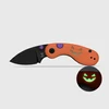 Halloween folding knife with orange handle, black blade, trick or treat text, and glow in the dark jack o lantern face