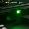 Compact EDC flashlight with green RGB lighting mode on a textured tactical gear surface