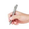 Hand holding a modern gray titanium click pen, poised for writing.
