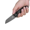 Hand holding Oknife folding pocket knife with black carbon fiber handle and grey steel blade isolated on white background