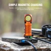 Orange LED headlamp charging with a magnetic cable connected to a power bank, outdoor scene.