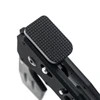 Textured black rectangular thumb rest mounted on a custom pistol frame isolated on white background