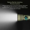 Green tactical flashlight with a rotary dial for stepless dimming and precise brightness control emitting bright light.